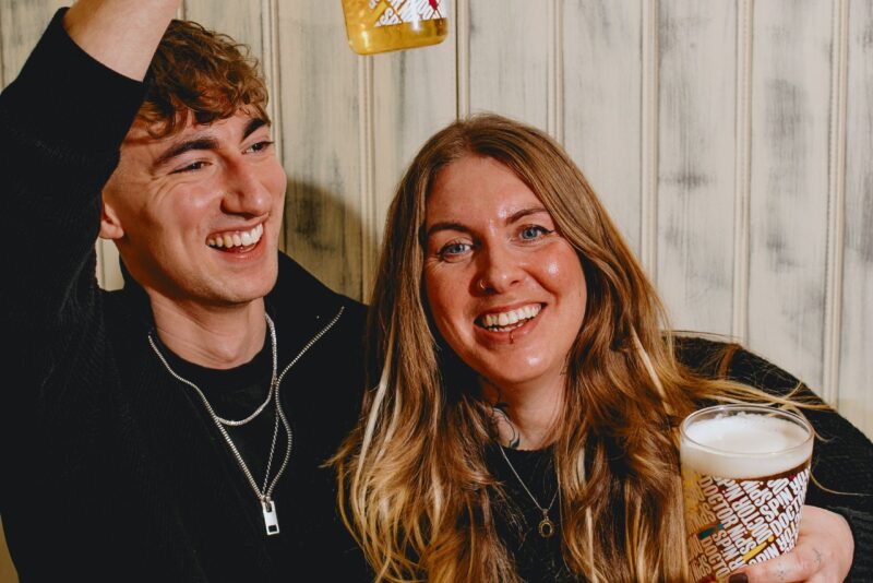 A man and a woman having a drink smiling